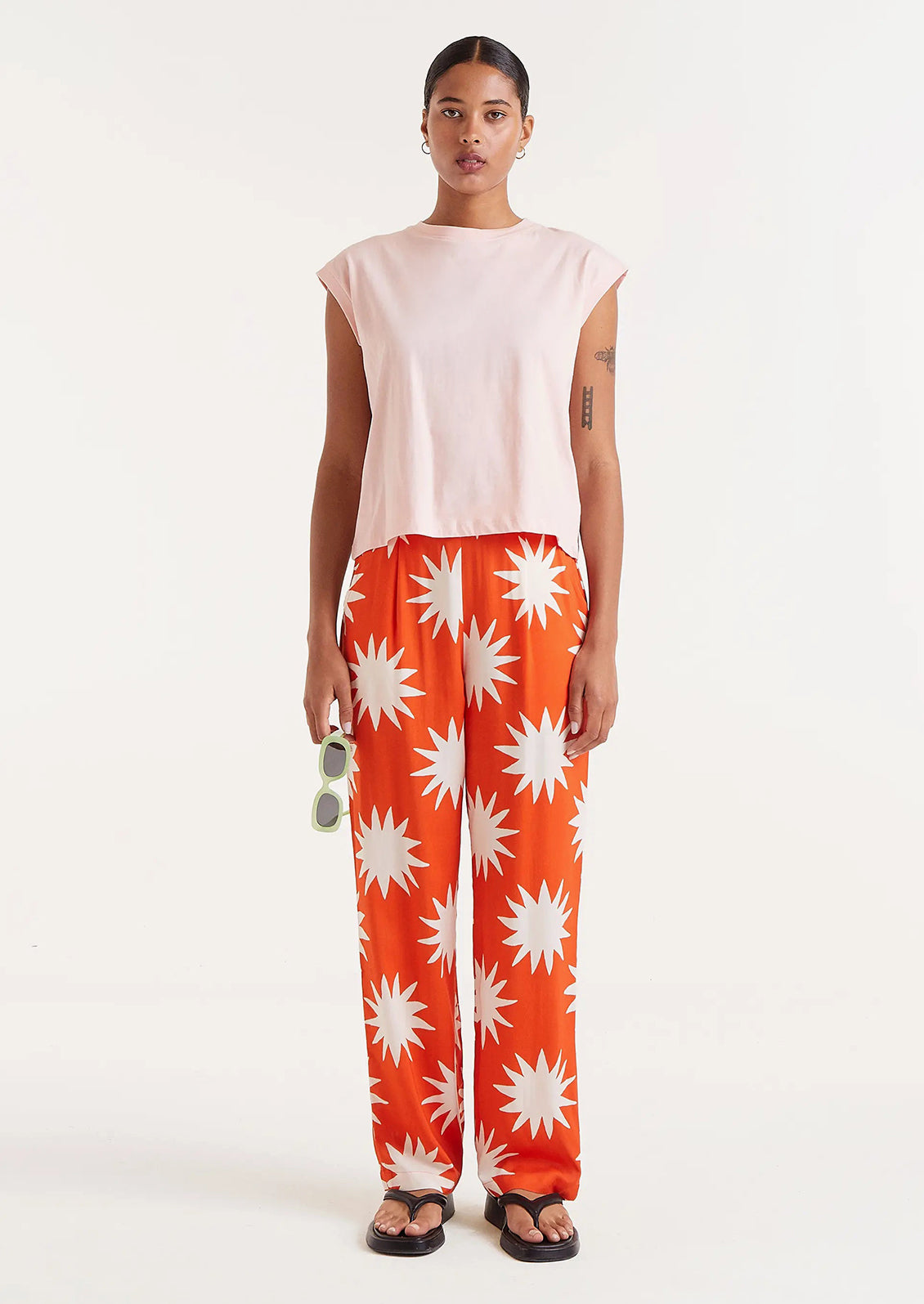 A pair of bright orange pants with white starburst print.