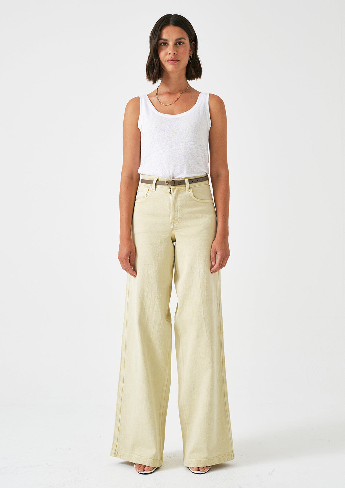 A person wearing a pair of long wide leg jeans in butter yellow color.