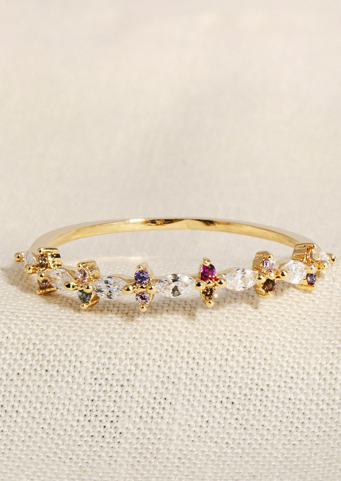 A gold ring with clear crystals surrounded by alternating color crystals.