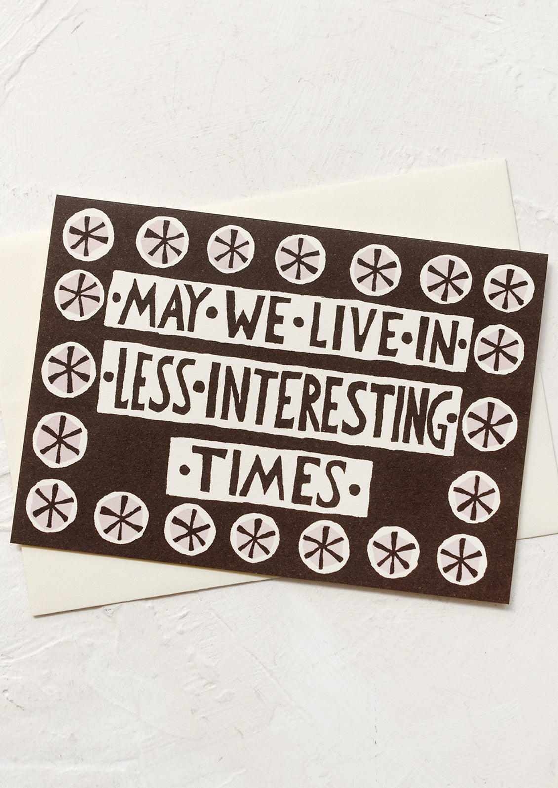 A card reading "May we live in less interesting times".