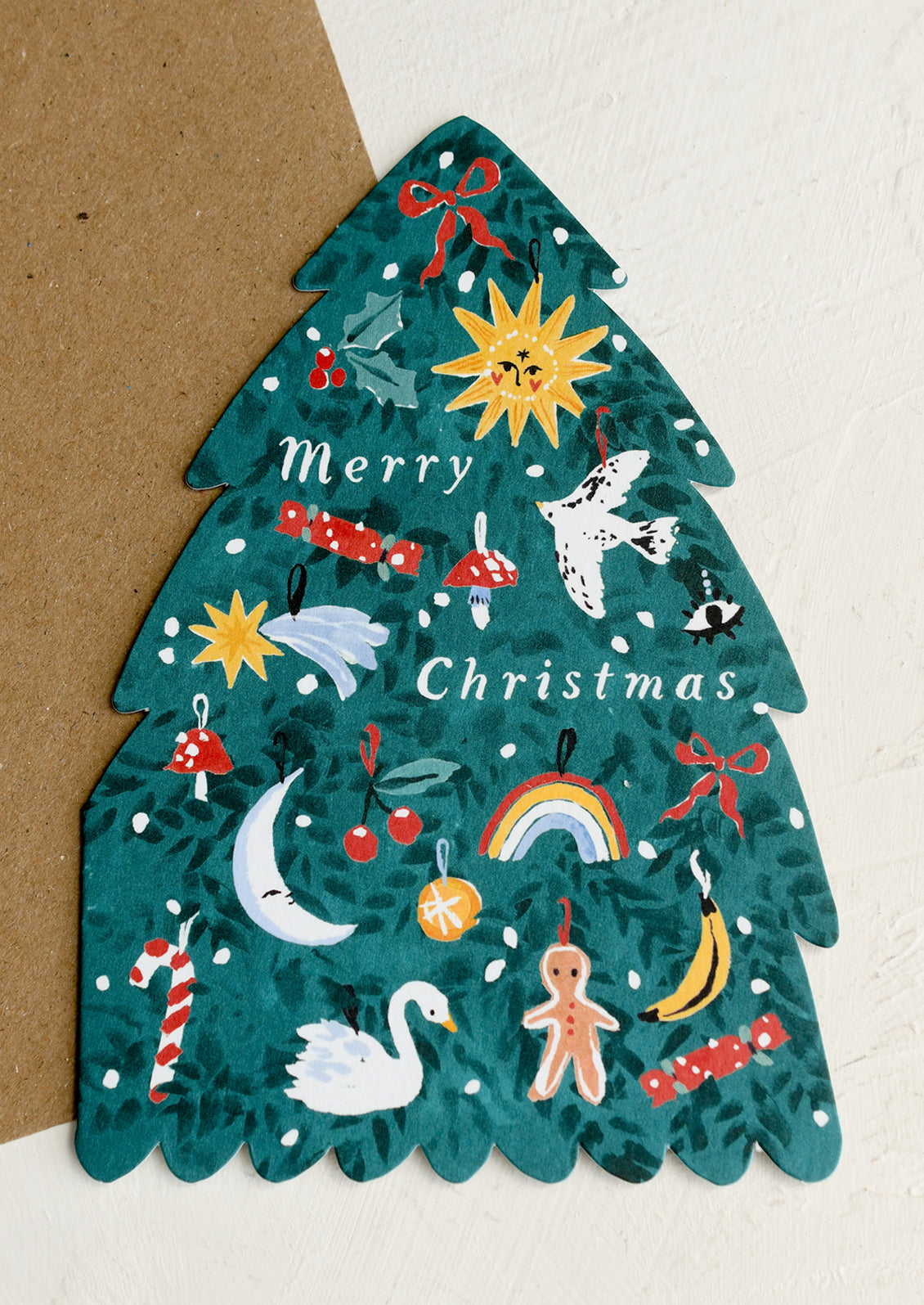 A diecut card in the shape of a Christmas tree adorned with decorations, text reads "Merry Christmas".