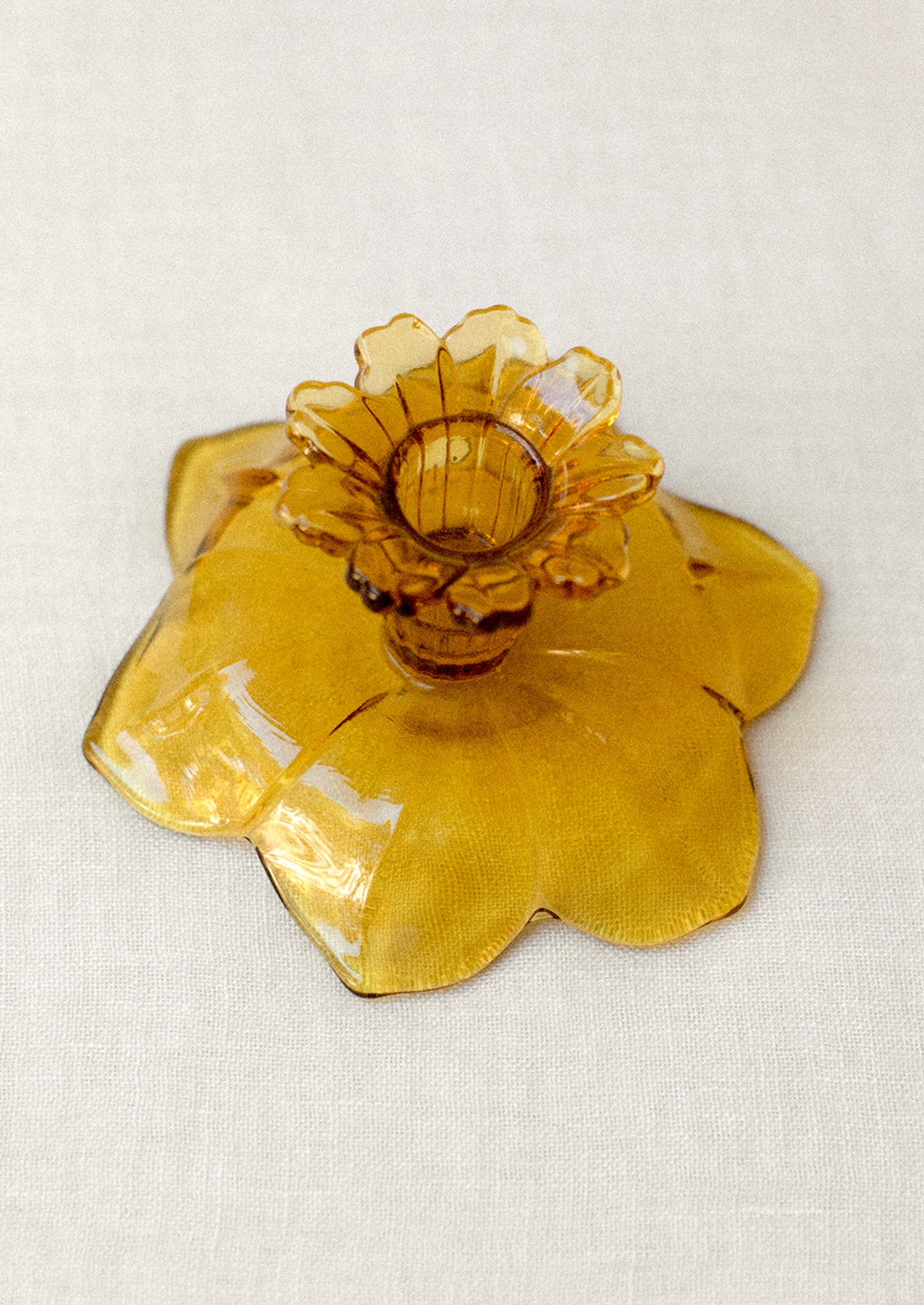 A pair of amber glass candle holders in the shape of daffodils.