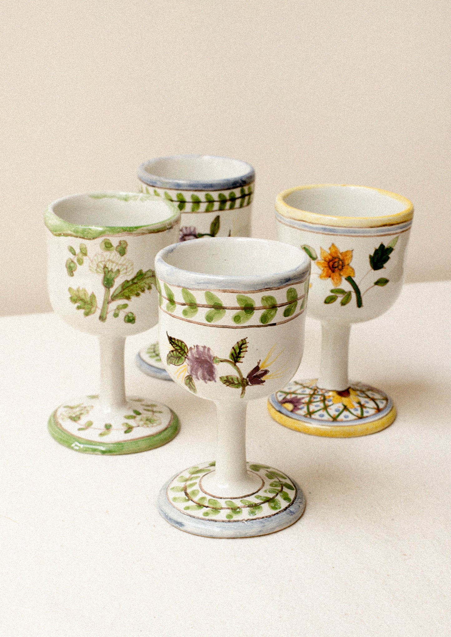 A set of four floral painted wine glasses.