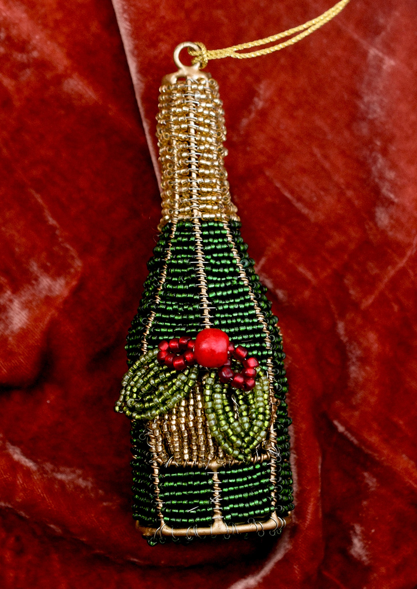 Decorative Christmas ornament shaped like a bottle with green and gold details on a red background