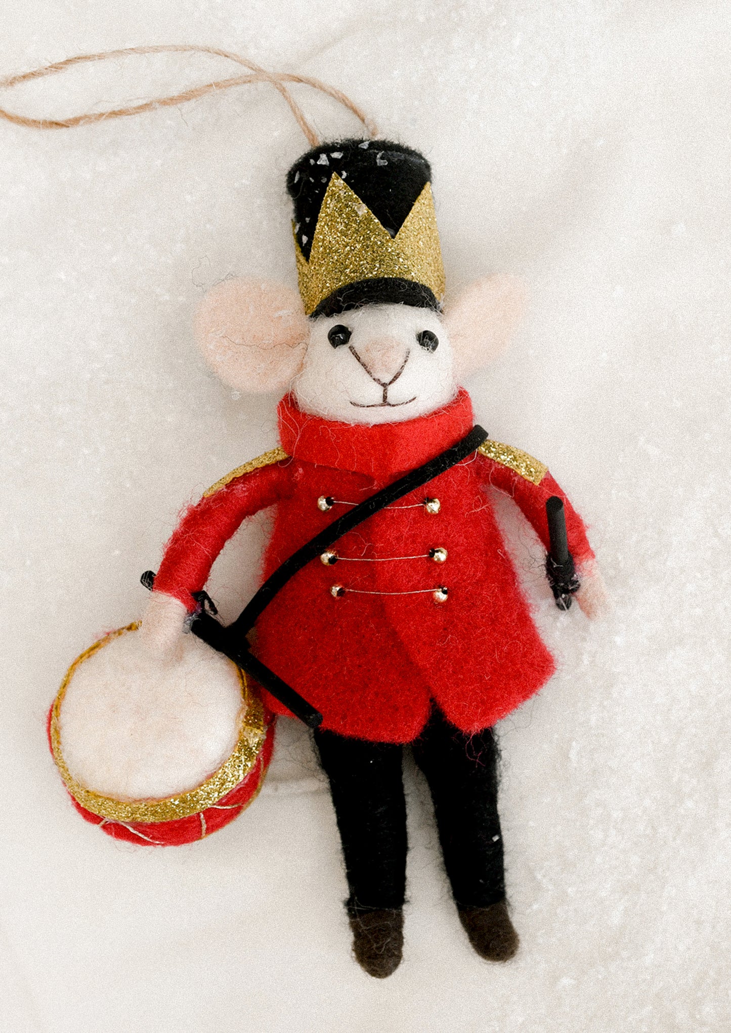 Mouse ornament in a red coat and black hat holding a drum.