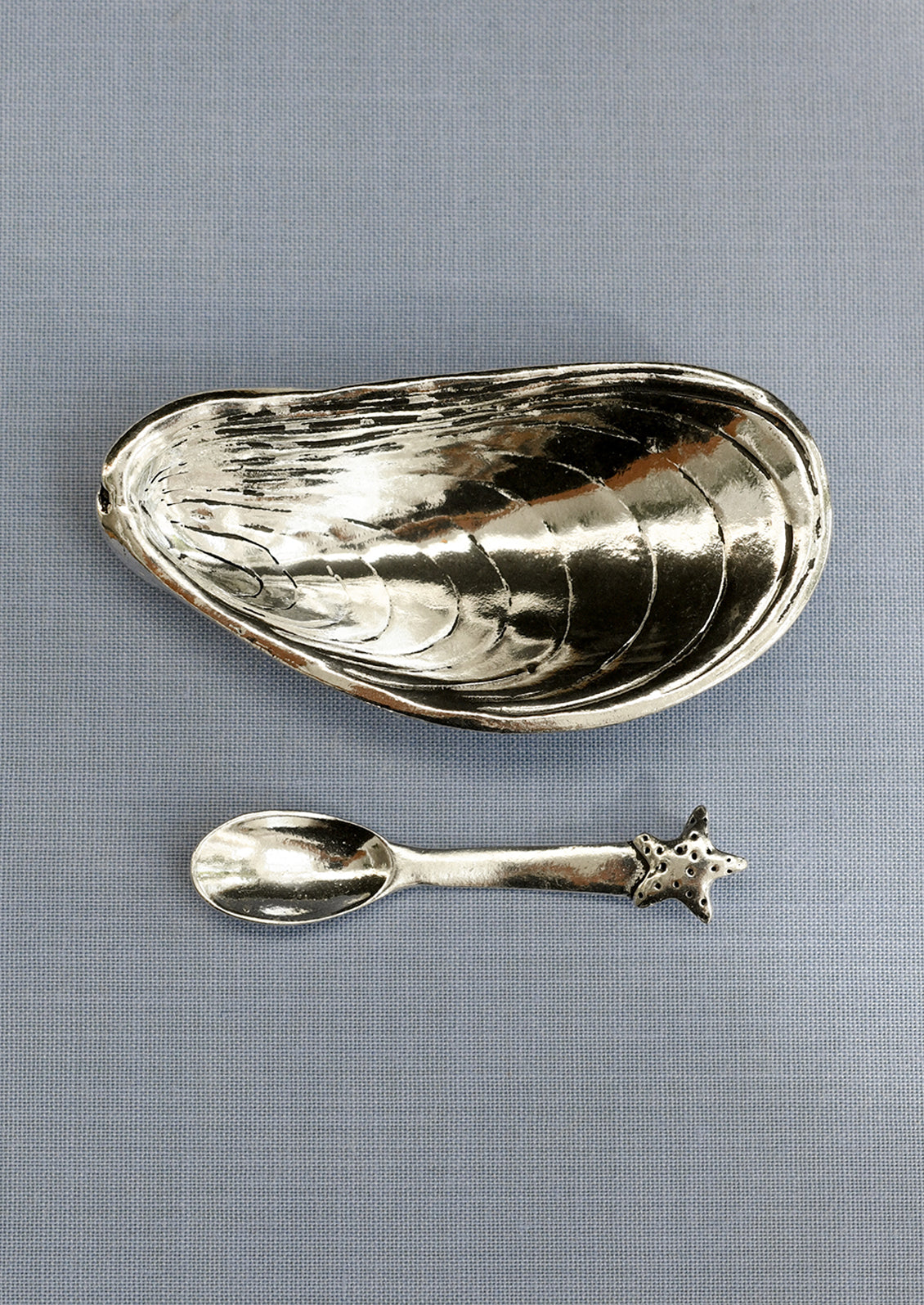 Silver mussel shaped salt cellar with a coordinating starfish spoon.