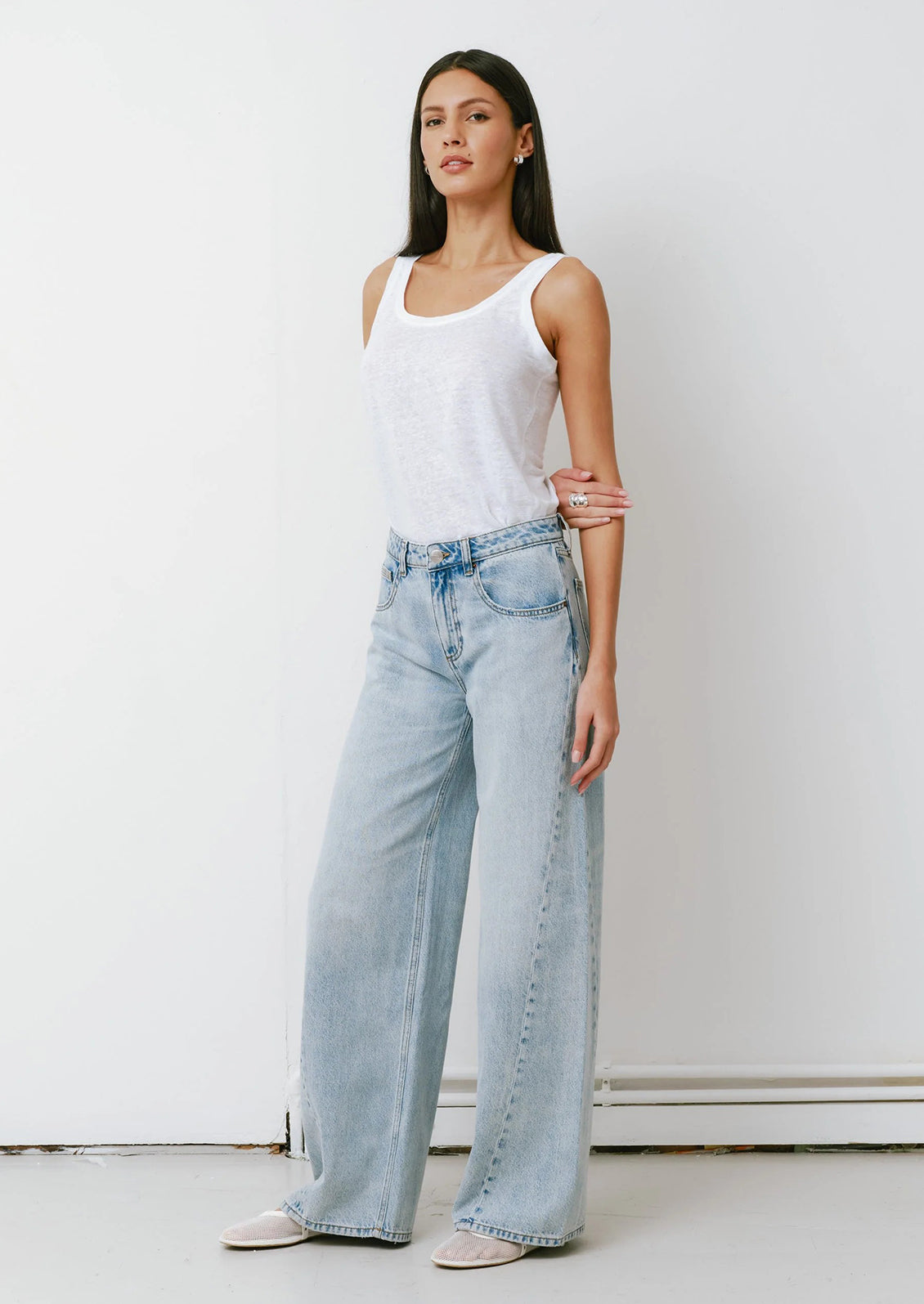 A woman wearing a pair of slouchy wide leg jeans in a light blue denim.