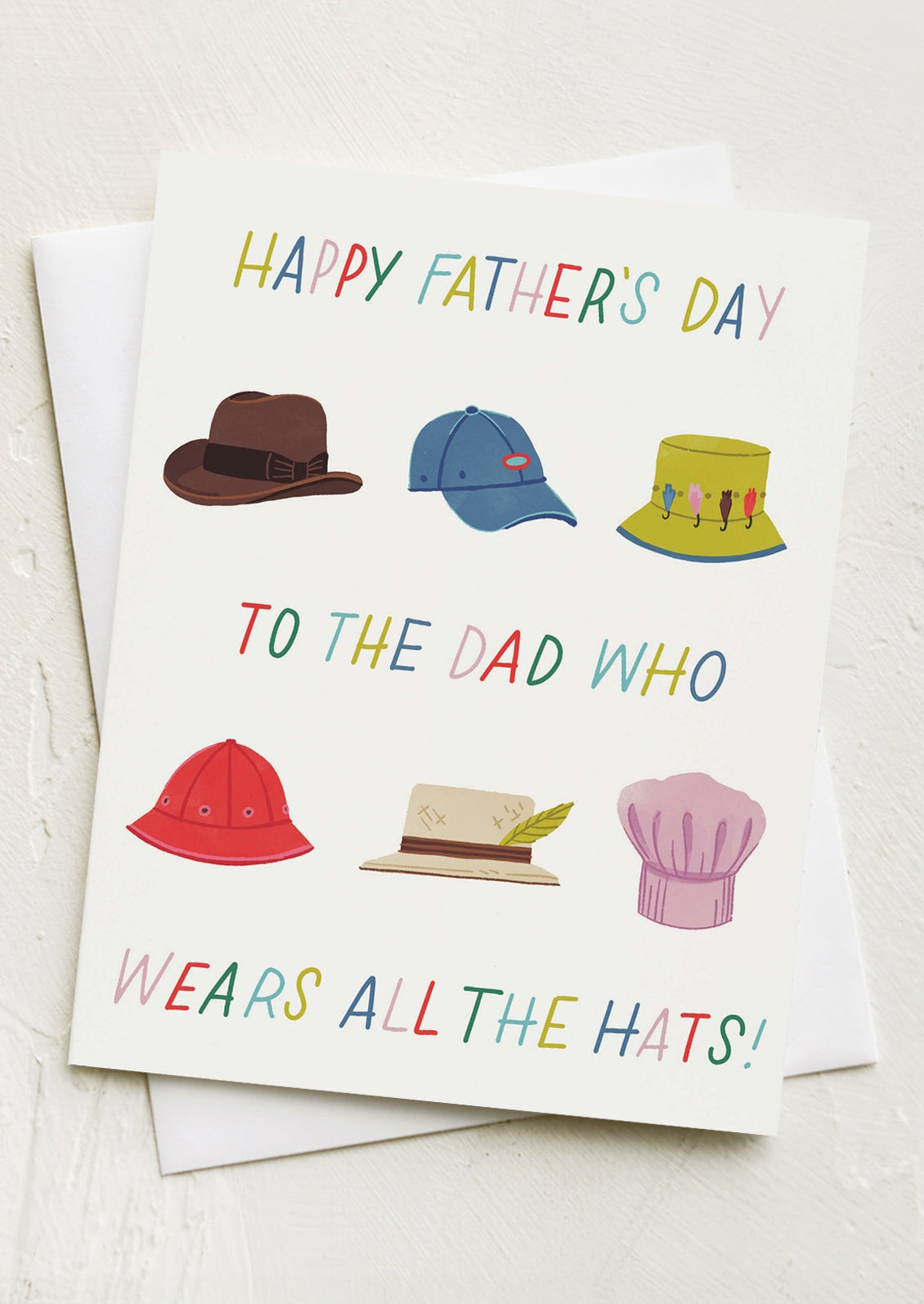 A greeting card with illustrations of different types of hats, text reads "Happy Father's Day To The Dad Who Wears All The Hats".