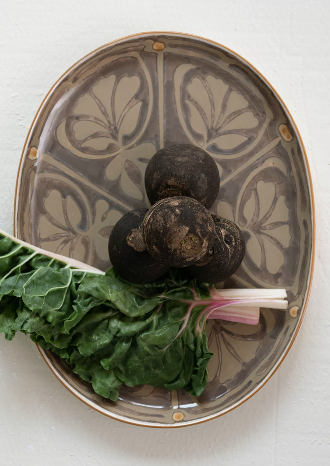 An oval platter in grey with brown Moroccan-inspired design.
