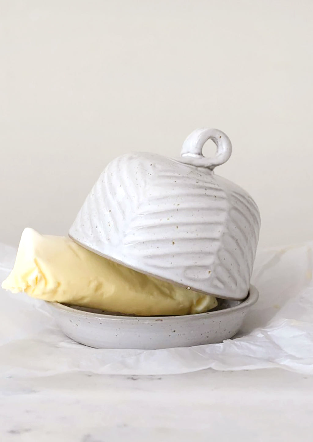 1: A ceramic butter dome in round shape with texture.