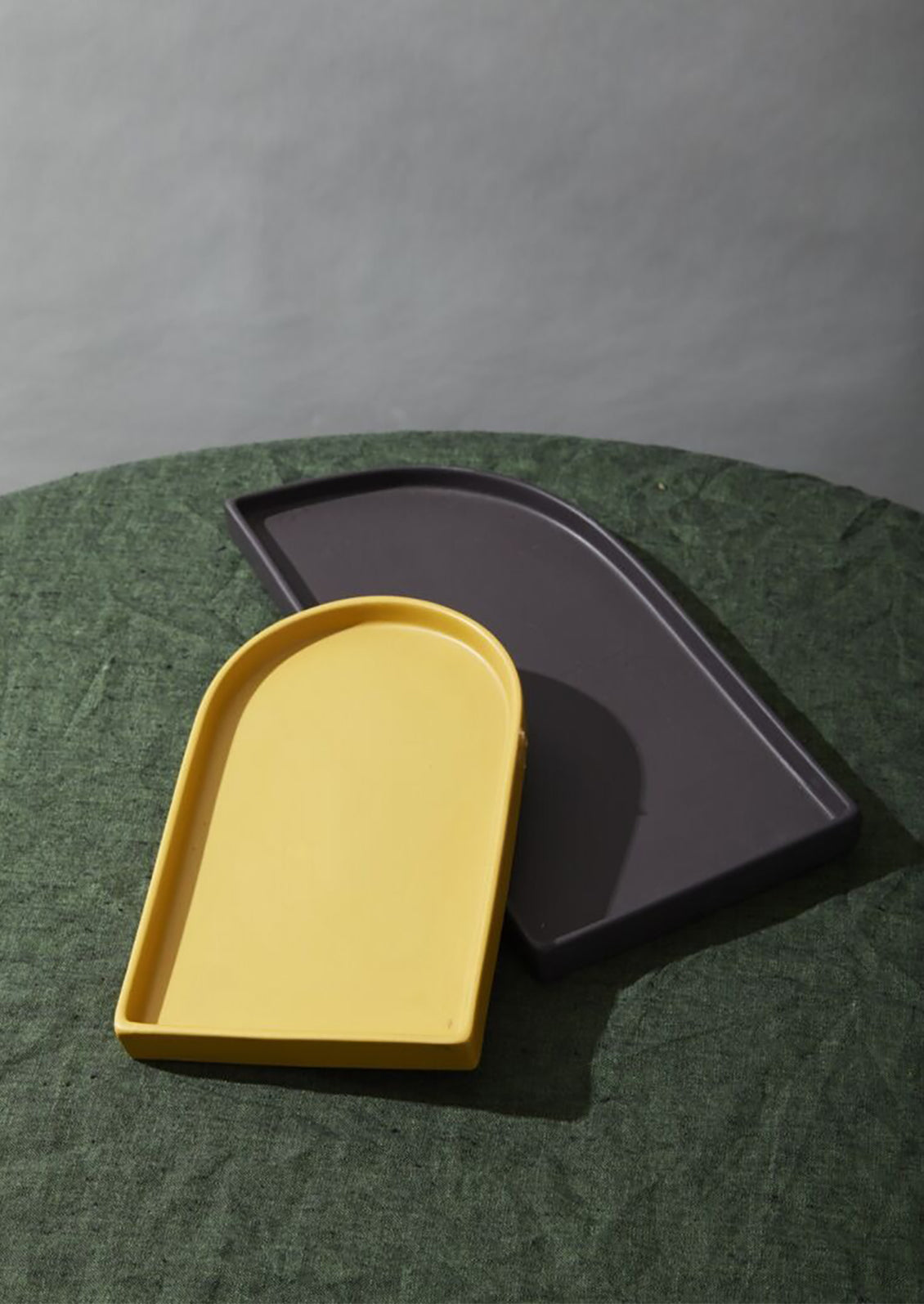 An egg yolk colored ceramic tray with arch shape.