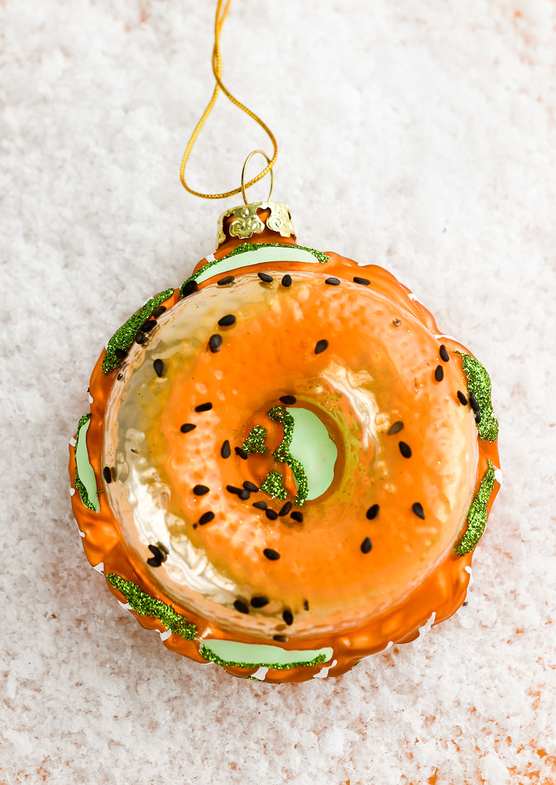 A glass ornament that looks like a bagel with lox.