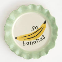 Go Bananas: A printed ceramic plate with mint colored rim and banana graphic, text reads "Go bananas".