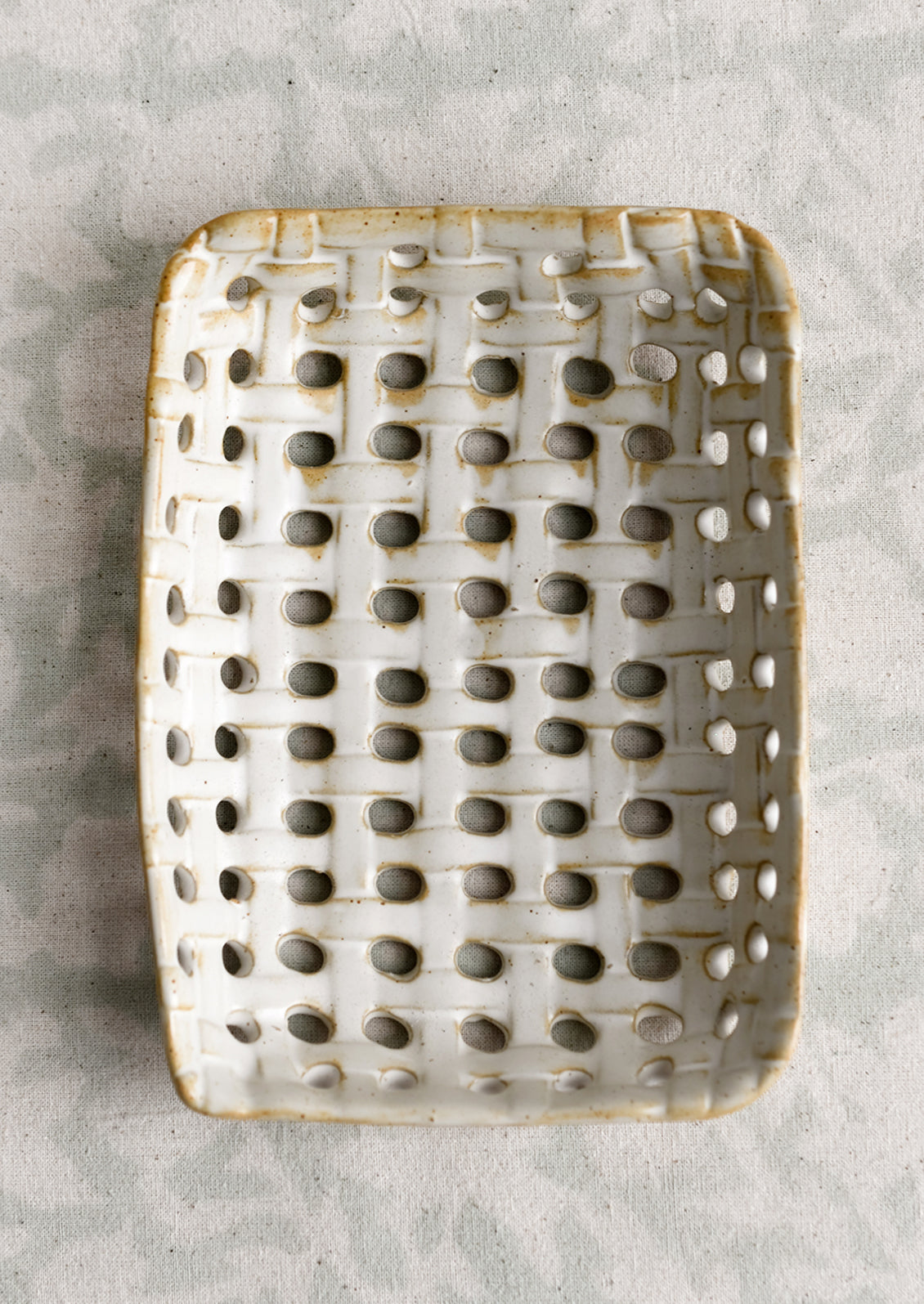 A rectangular shaped ceramic tray with open basketweave design.