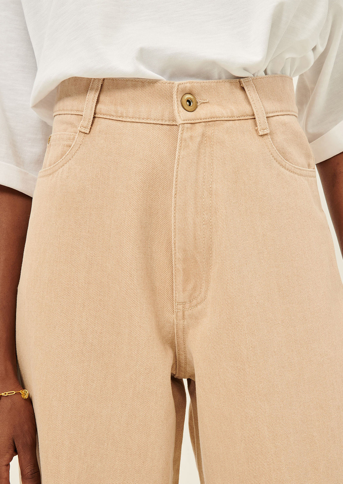 A close-up of a woman wearing light clay-dyed jeans.