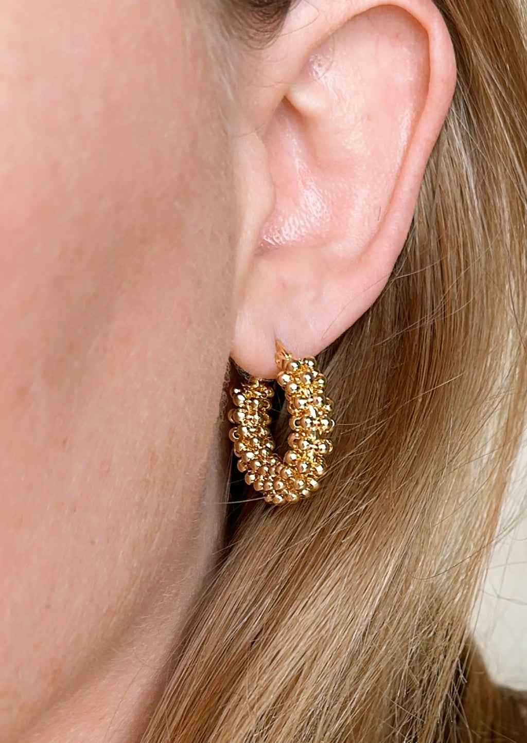 2: A pair of hoop earrings with all around cluster beading.