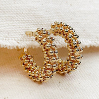 1: A pair of hoop earrings with all around cluster beading.