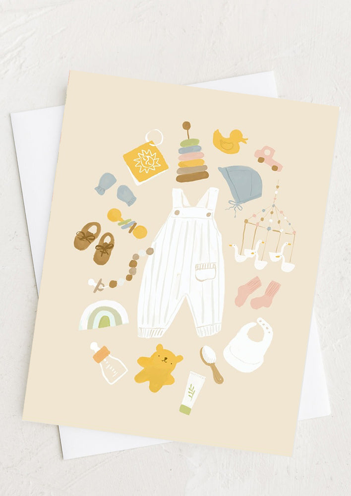 1: A pastel colored greeting card with baby items illustration.