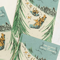 1: Greeting cards with illustration of dogs sledding down a hill, text reads "The Holidays Are Better Together".
