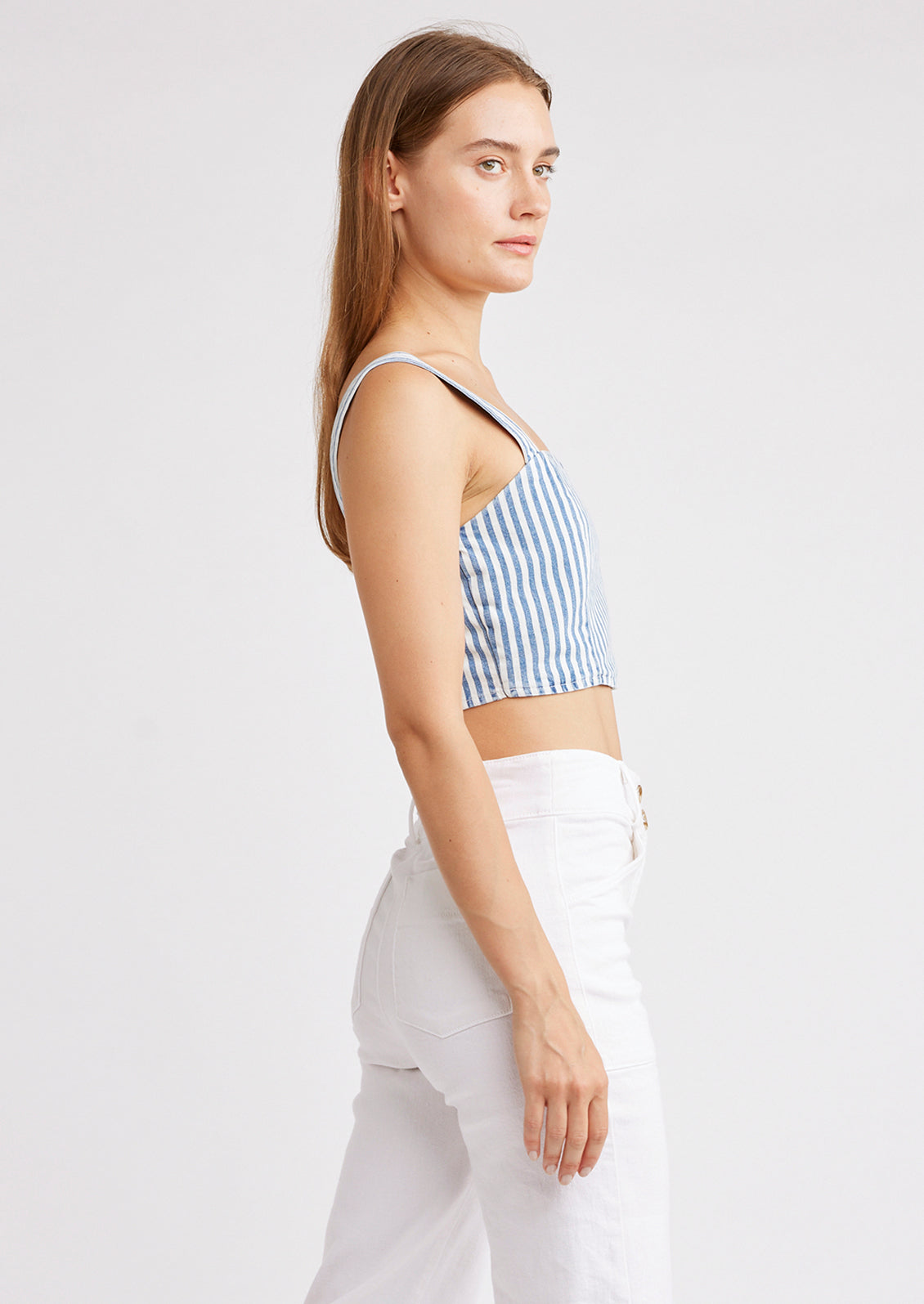 A woman wearing a square neck crop top with smocked elastic back.