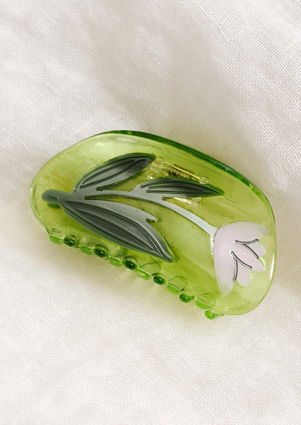 Green / Lily: A transparent green curved shape hair claw with lily design.