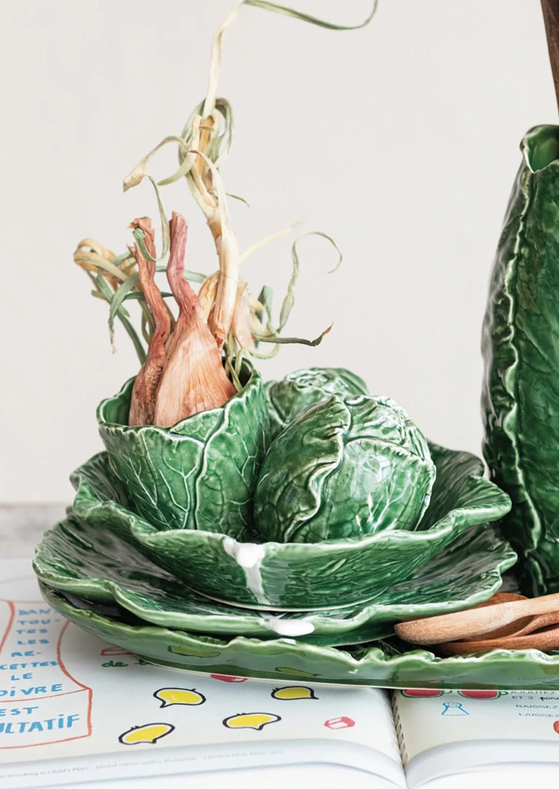 A ceramic serving "cabbageware" style bowl that looks like green leaf of cabbage.