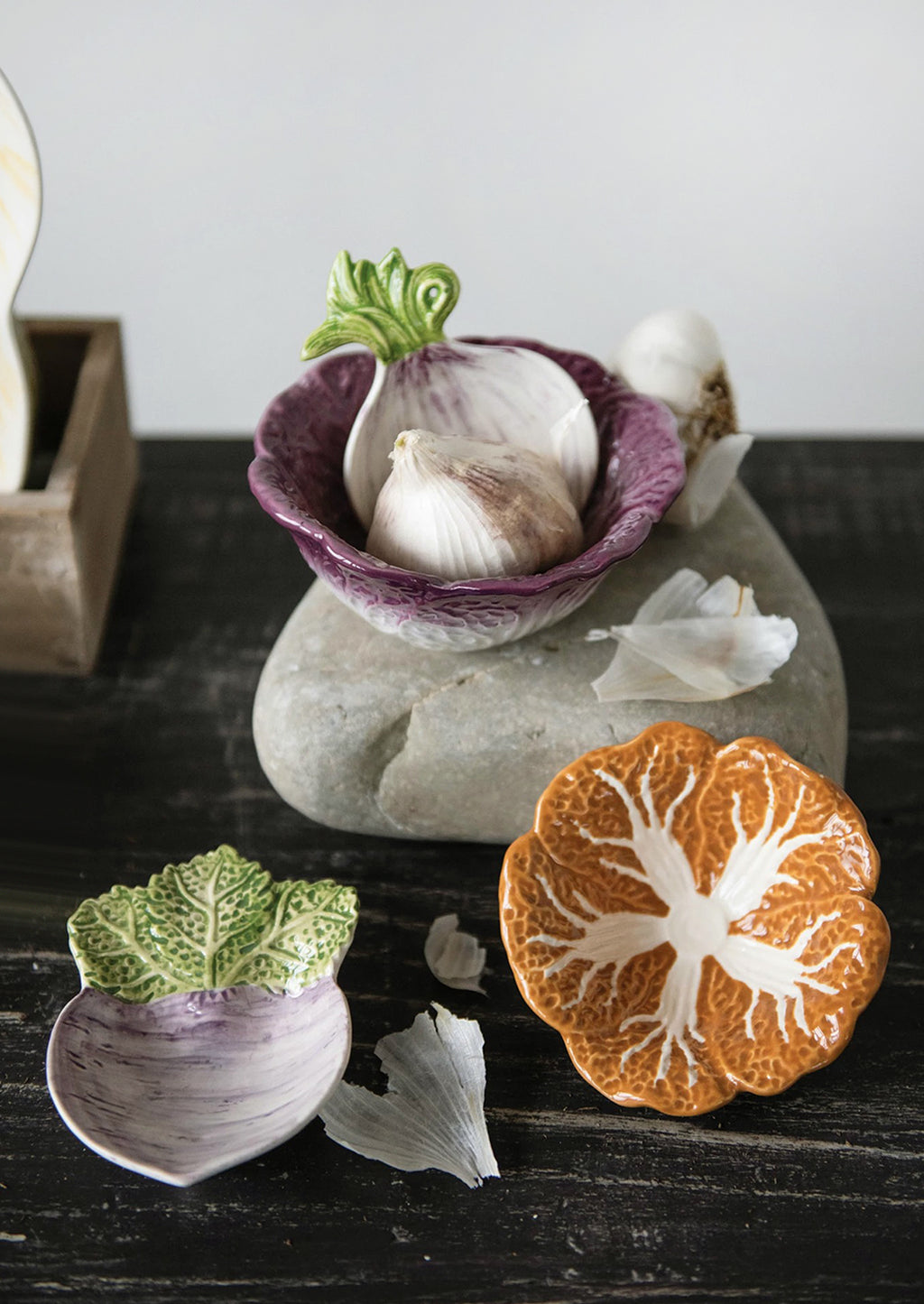 3: A pair of ceramic nesting bowls that look like orange and purple cabbage.