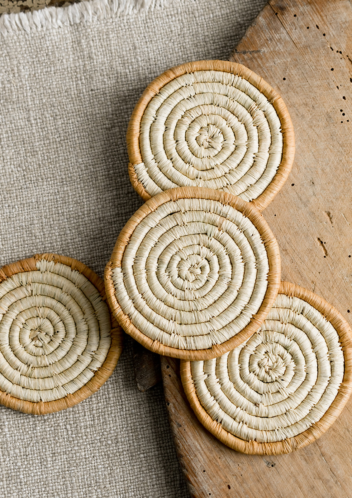 A set of natural raffia coasters with tan border.