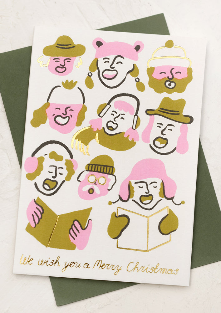 A card with cartoon-like illustrations of carolers, text reads "We wish you a merry christmas".