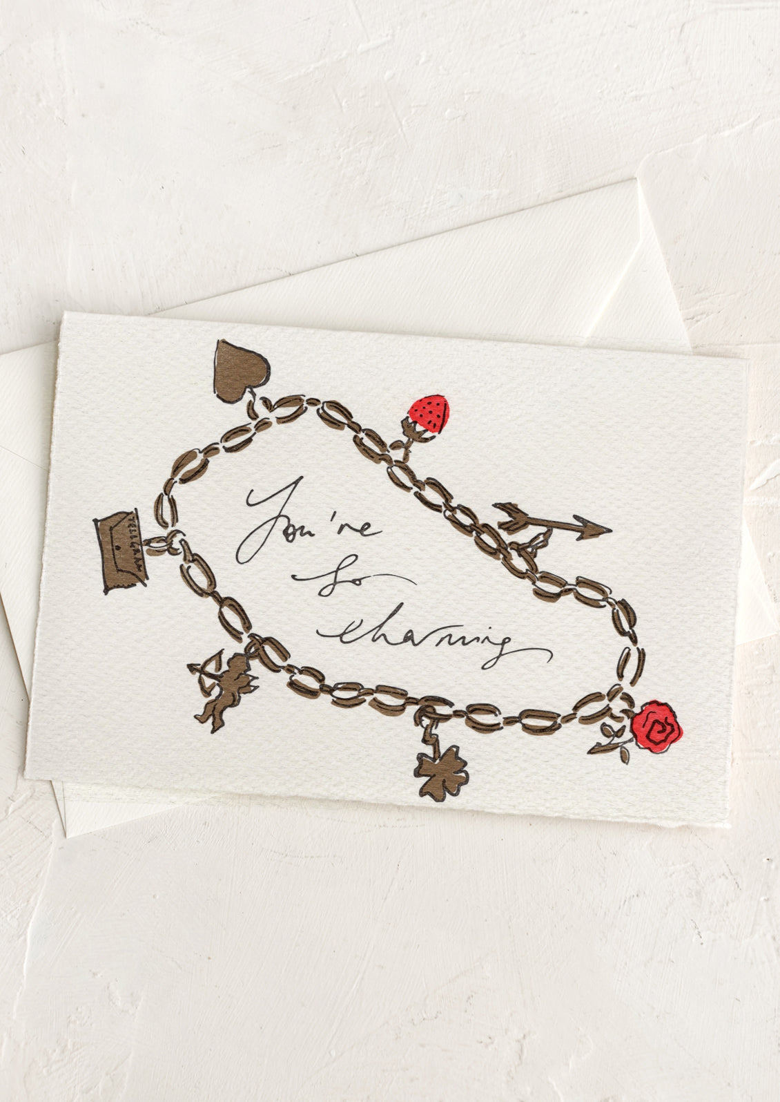 A card with hand painted illustration of a charm bracelet, text reads "You're So Charming".