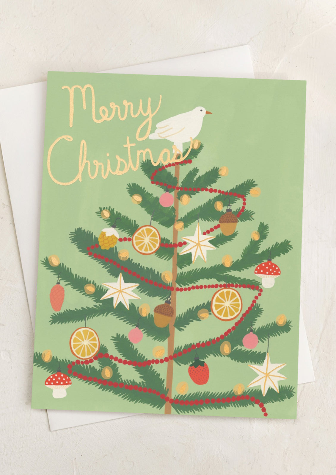 A green card with illustration of Christmas tree decorated with dove and garland, text reads "Merry Christmas".