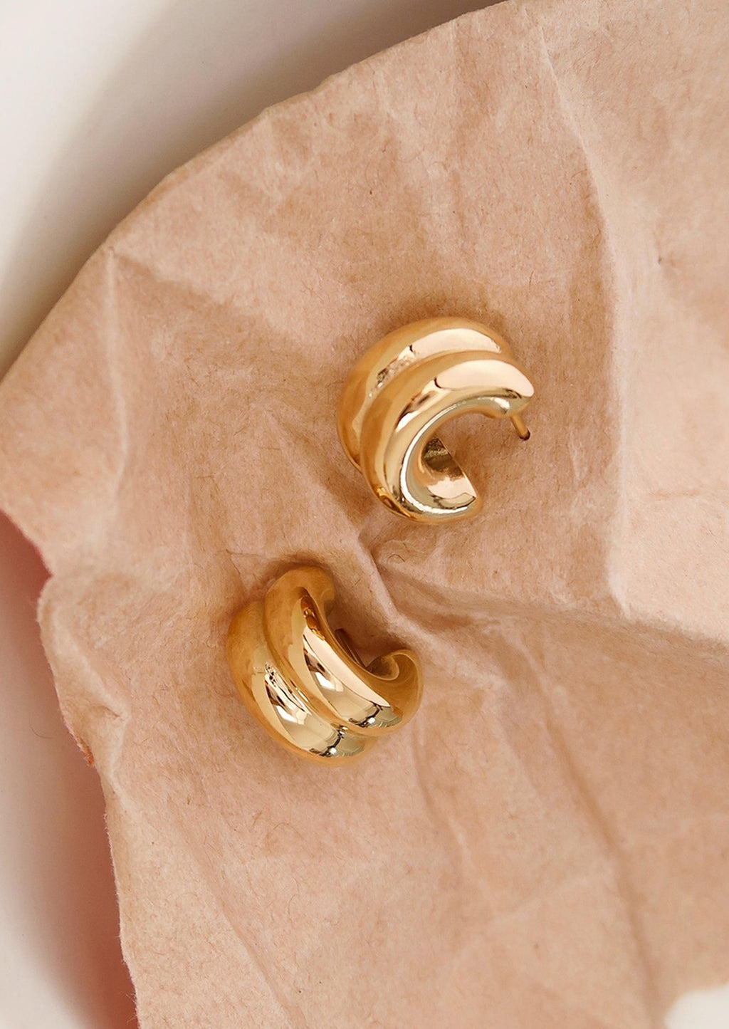 Gold: A pair of chunky rib textured hoop earrings in gold.