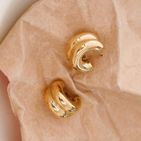 Gold: A pair of chunky rib textured hoop earrings in gold.