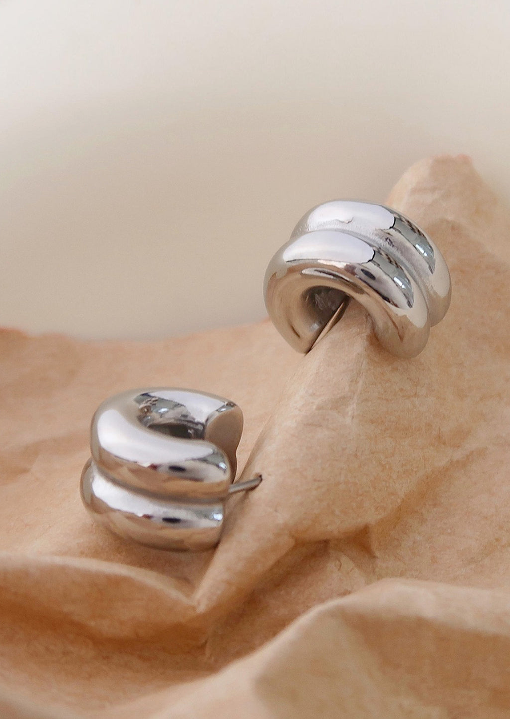 3: A pair of chunky rib textured hoop earrings in silver.