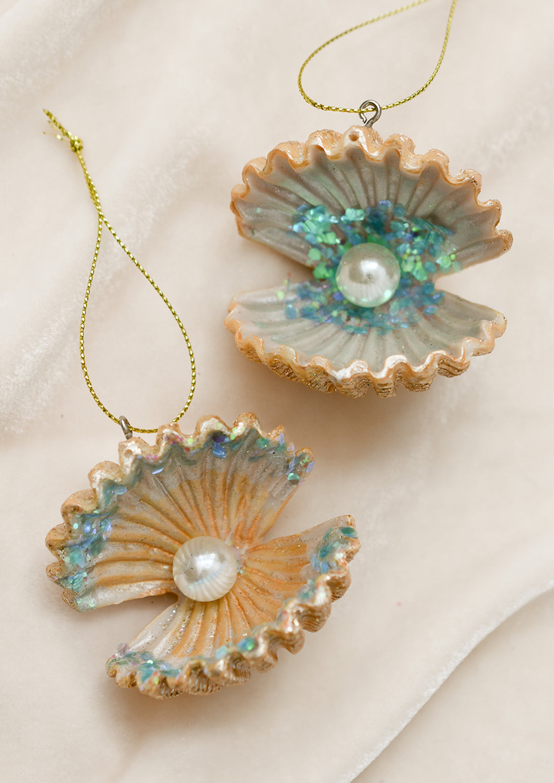 Shell ornaments with open oyster shell with pearl and glitter inside.