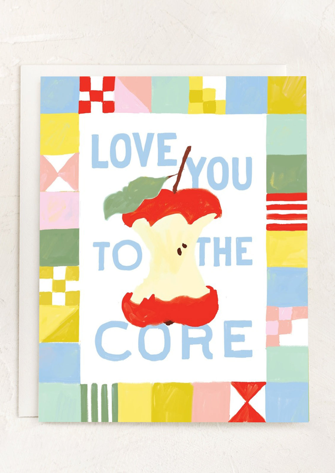 A quilt print card with apple at center, text reads "Love you to the core".