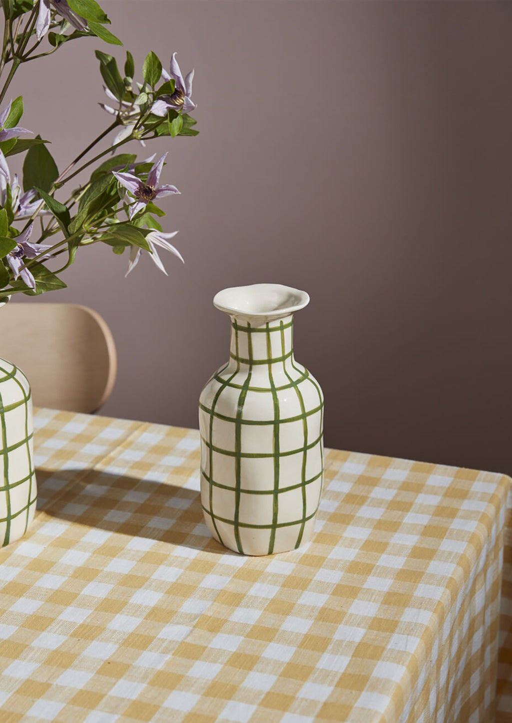 2: A ceramic vase in white with green grid pattern.