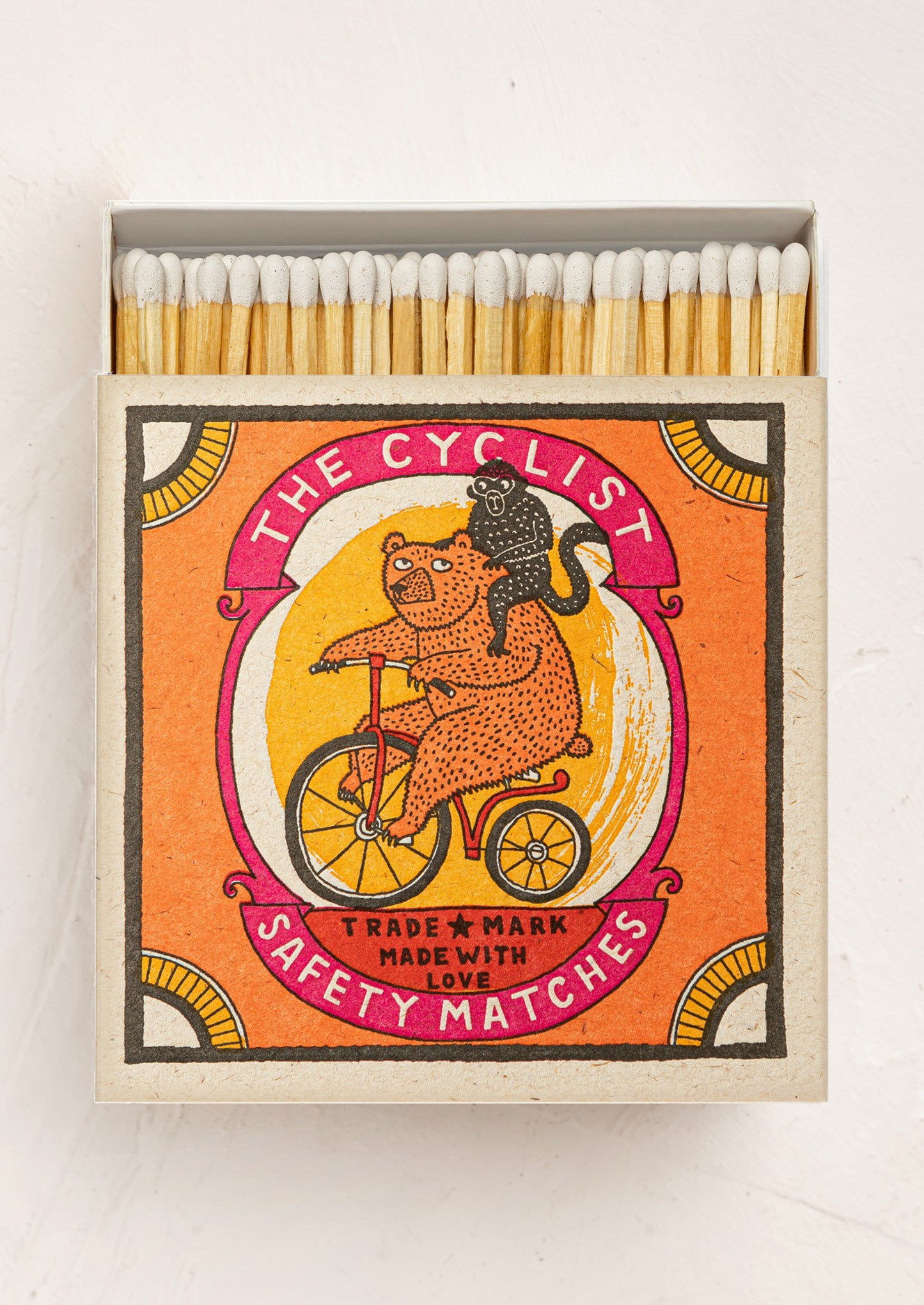 Matches box with a bear and cat design on an orange background.