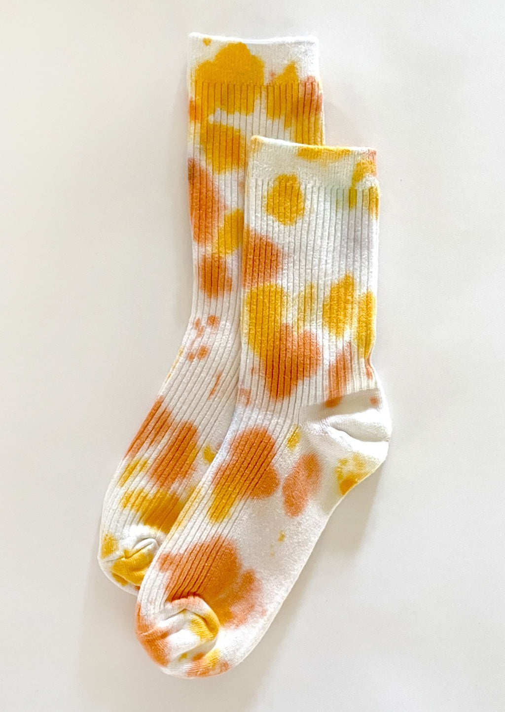 Daisy: A pair of tie dye socks in yellow and orange color.