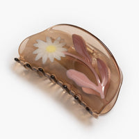 Smoky Quartz / Daisy: A transparent brown curved shape hair claw with daisy design.