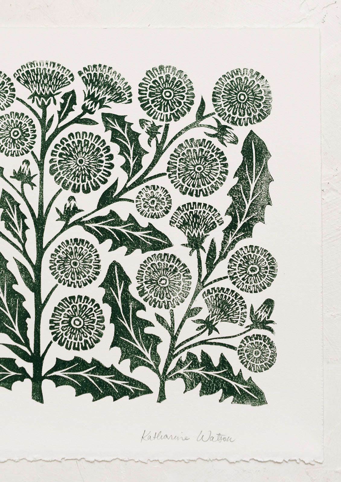 A woodblock print of dandelion flowers in dark green ink.