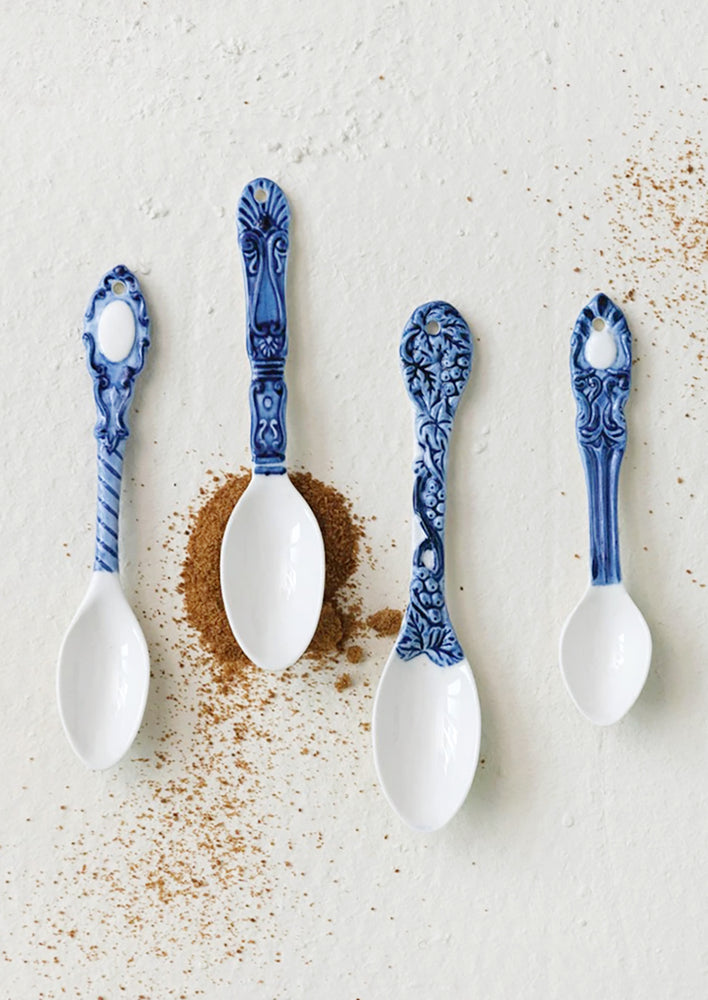White ceramic spoons with ornate blue handles.