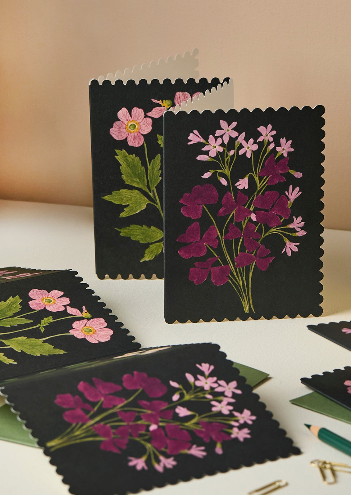 An accordion folded concertina card with floral paneled illustrations on black background.