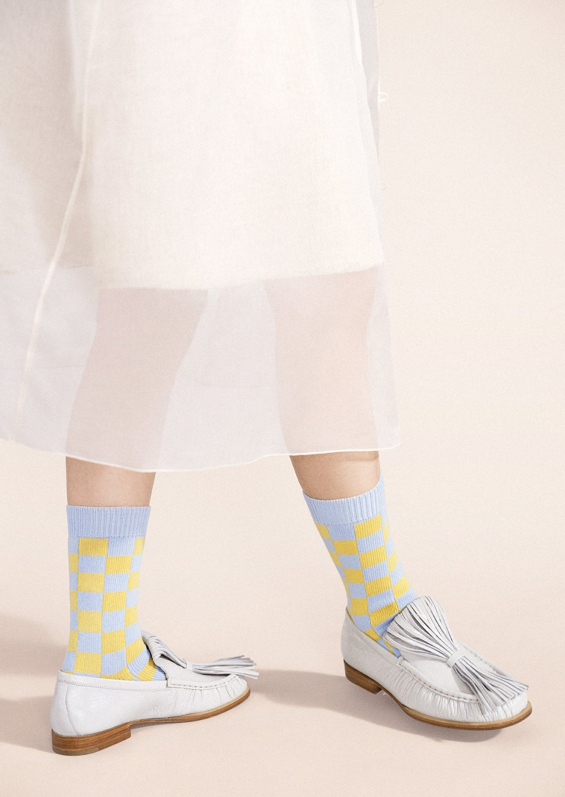 A person wearing a pair of blue and yellow checkered socks.