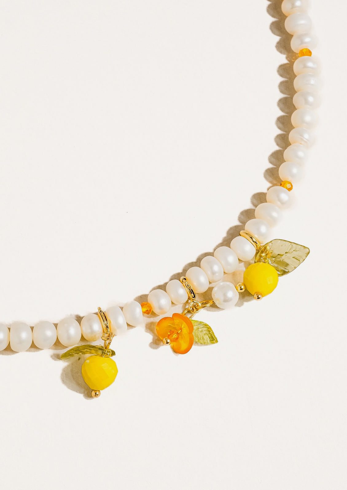A beaded pearl necklace with lemon charms.
