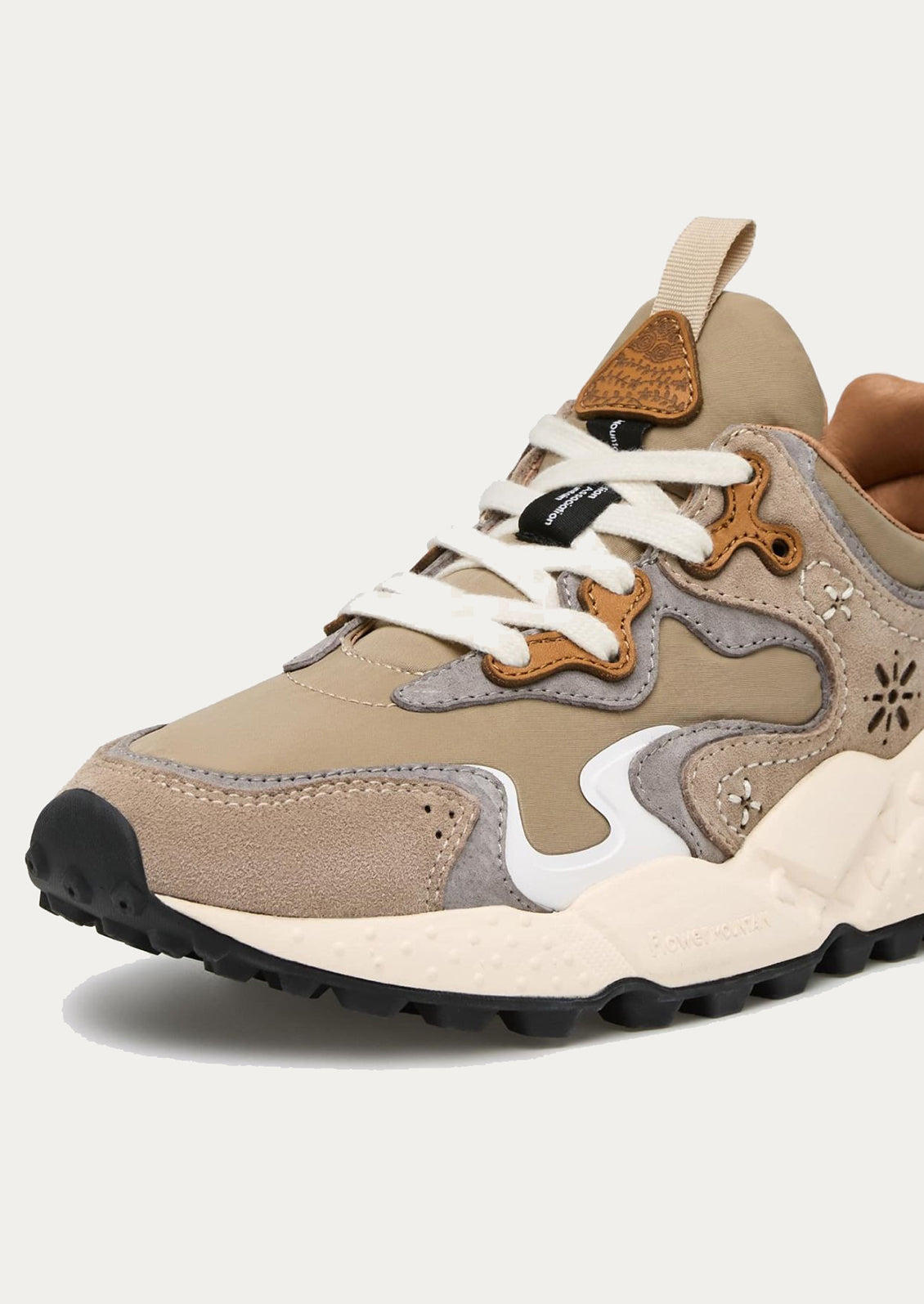 A sporty unisex sneaker in taupe, grey and brown.