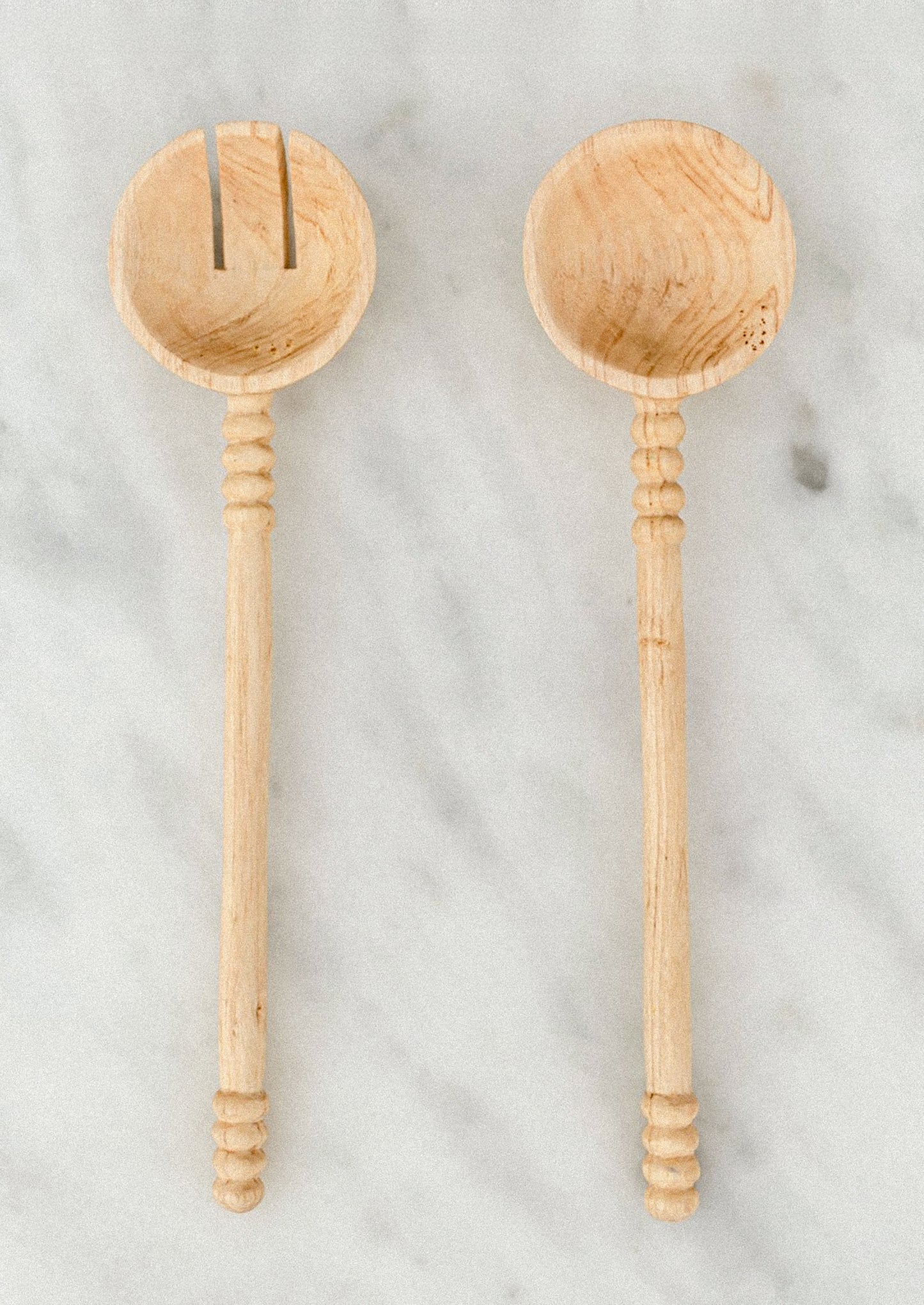 Two wooden spoons on a marble surface
