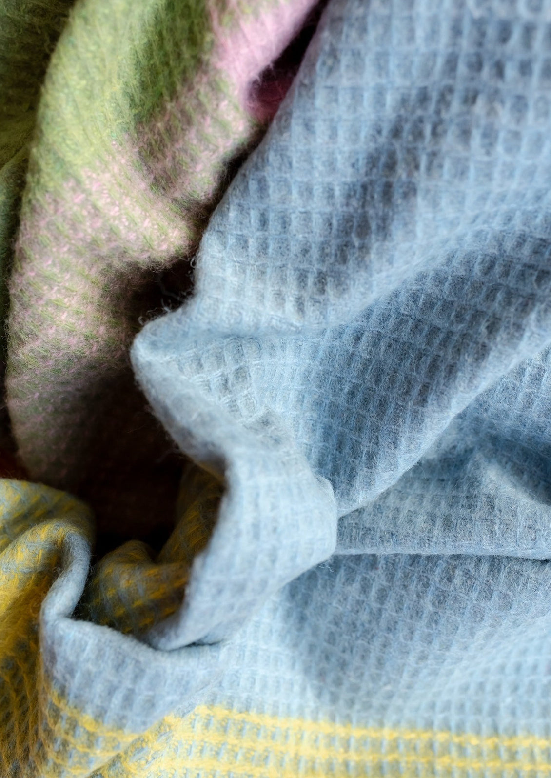 A waffle textured throw blanket in pastel check pattern.