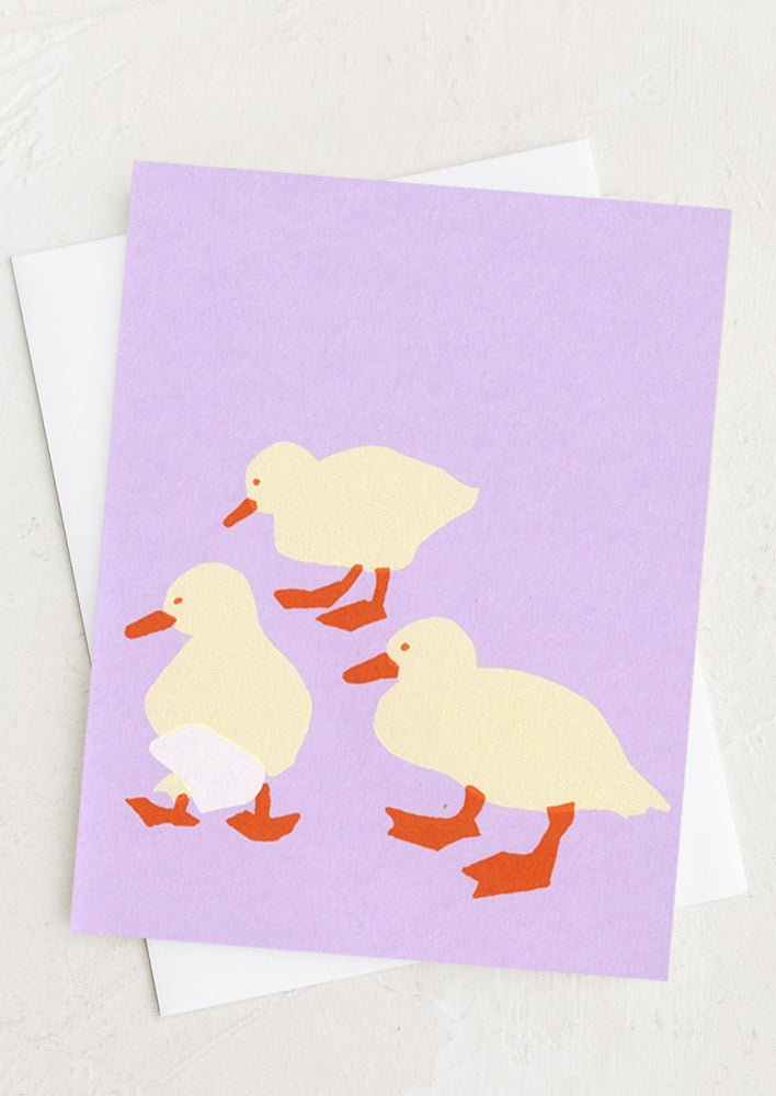 A purple greeting card with screenprinted ducklings design.