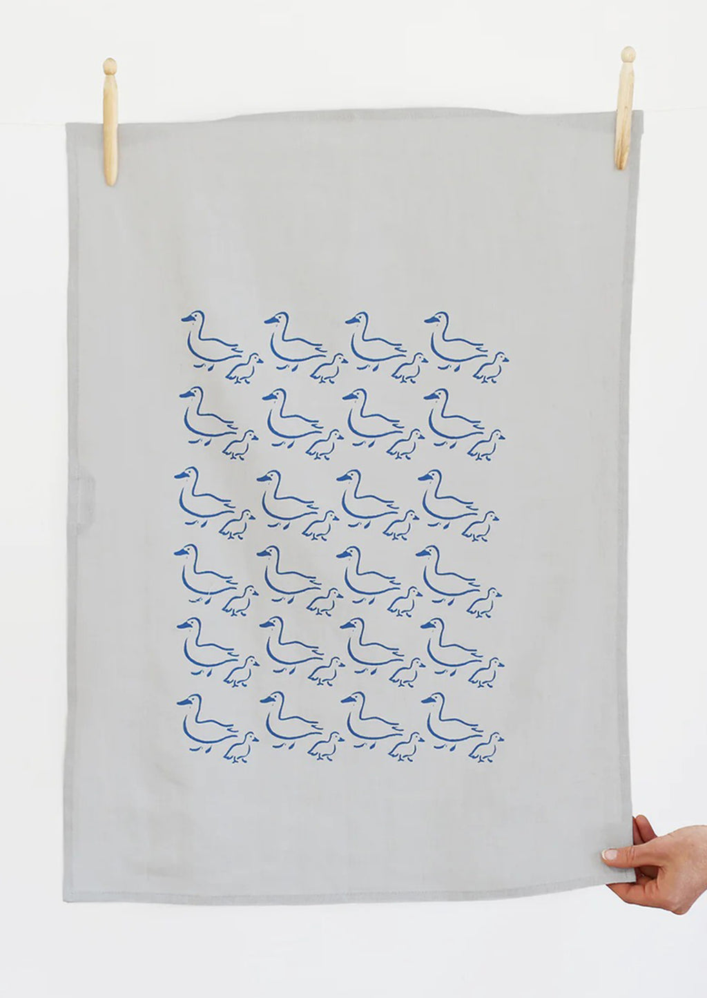 2: A grey linen tea towel with blue duck illustration print.